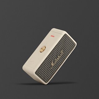 어두운 배경에 황동 컨트롤 노브와 프렛이 있는 크림색 Marshall Emberton II 휴대용 Bluetooth 스피커입니다.