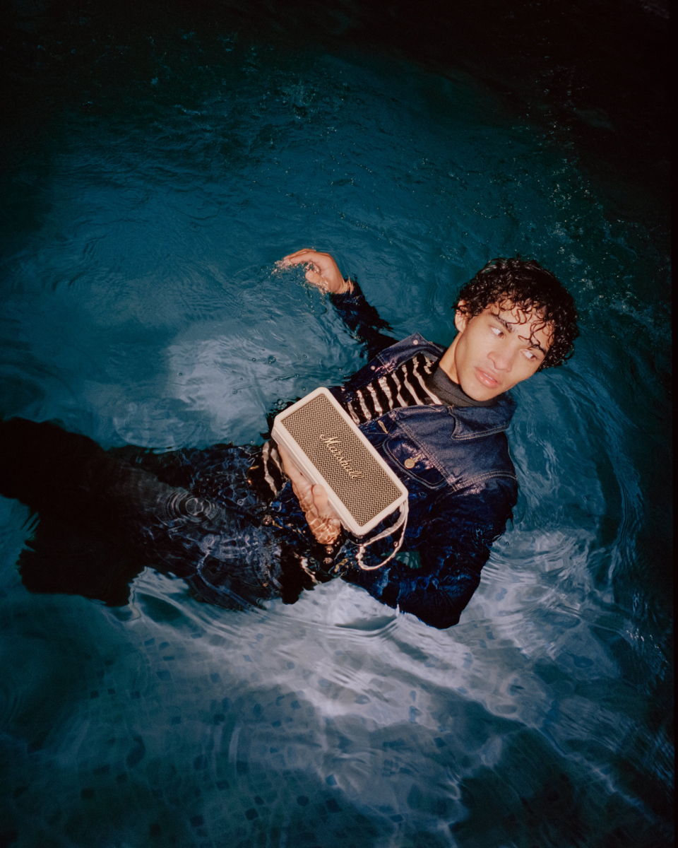 Man swiming holding a Marshall Middleton Speaker