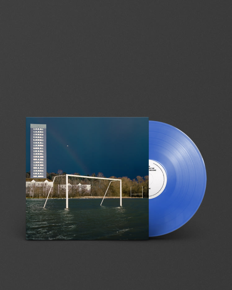 A blue vinyl lp of "We Don't Like The People We've Become" by Gallus, with a building in the background.