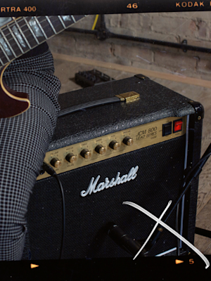 Someone sitting with a guitar on a Studio Classic Combo.
