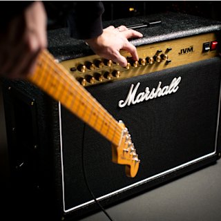 A person with a guitar and a Marshall JVM205 Combo in black and gold