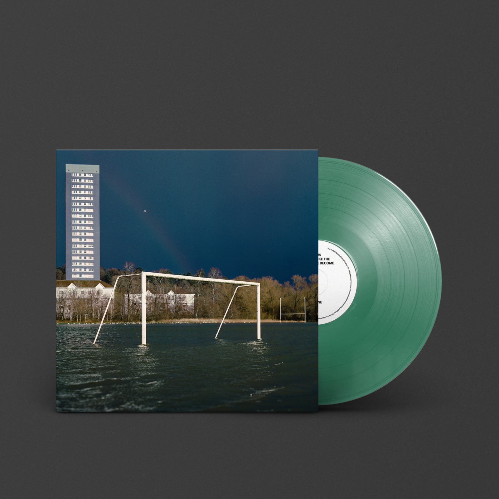 Un disque vinyle vert de "We Don't Like The People We've Become" de Gallus avec un bâtiment en arrière-plan.