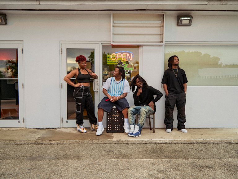 Denzel Curry and friends standing in front of an open store