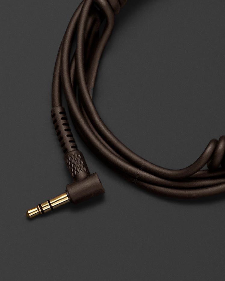 Un cable de audio para auriculares Marshall sobre una superficie negra.