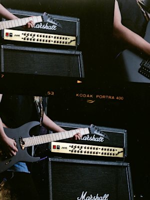 A person is playing a electric guitar beside a Marshall JVM410 Head.