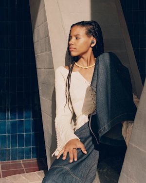 Girl listening to music in a Marshall Noise Cancelling Earbud.