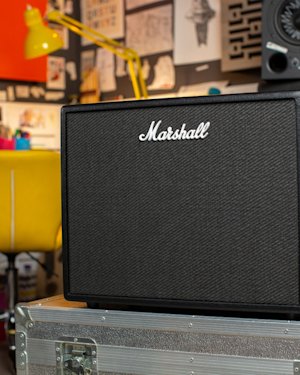 The Marshall CODE50 Combo on the case in the room with a guitar, home speaker and monitor speakers.