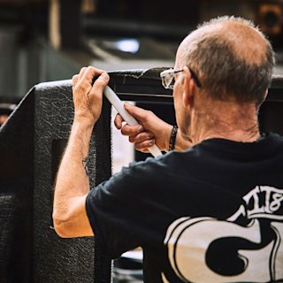 A Marshall factory worker adding the checking the back of an amplifier