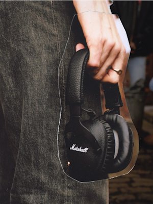 A person is holding a pair of Marshall MONITOR II ANC headphones.