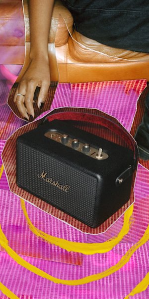 The Marshall Kilburn III Cream speaker on top of a wooden chair