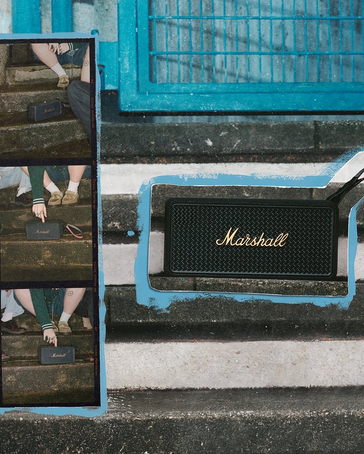 Marshall Middleton II Black and Brass portable Bluetooth speaker sits on concrete steps next to a blue metal fence.