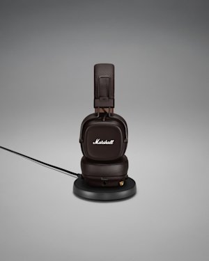 Marshall MAJOR IV headphones displayed on a sleek black stand.