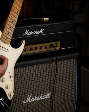 A black and white guitar plugged into the Marshall 1987X Vintage Reissue Head amplifier.