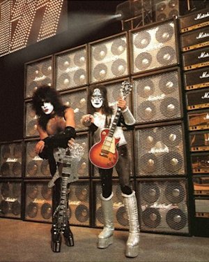 A poster of KISS standing in front of a wall of Marshall heads and cabinets