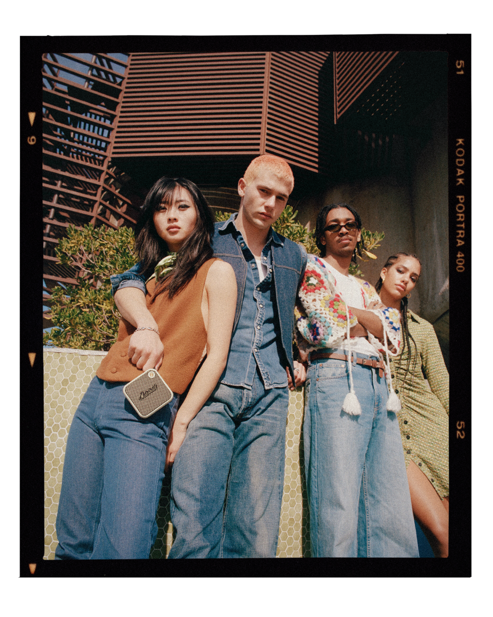 A group of people posing for a photo with a Marshall WILLEN portable speaker.