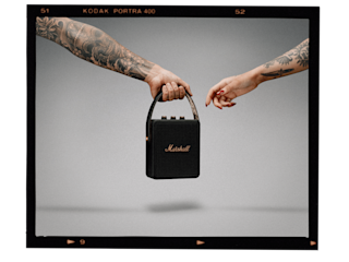 A photo of two people with tattoos holding a Marshall Stockwell II portable speaker.