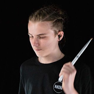 A face picture of Angus Glover using a Natal drums shirt