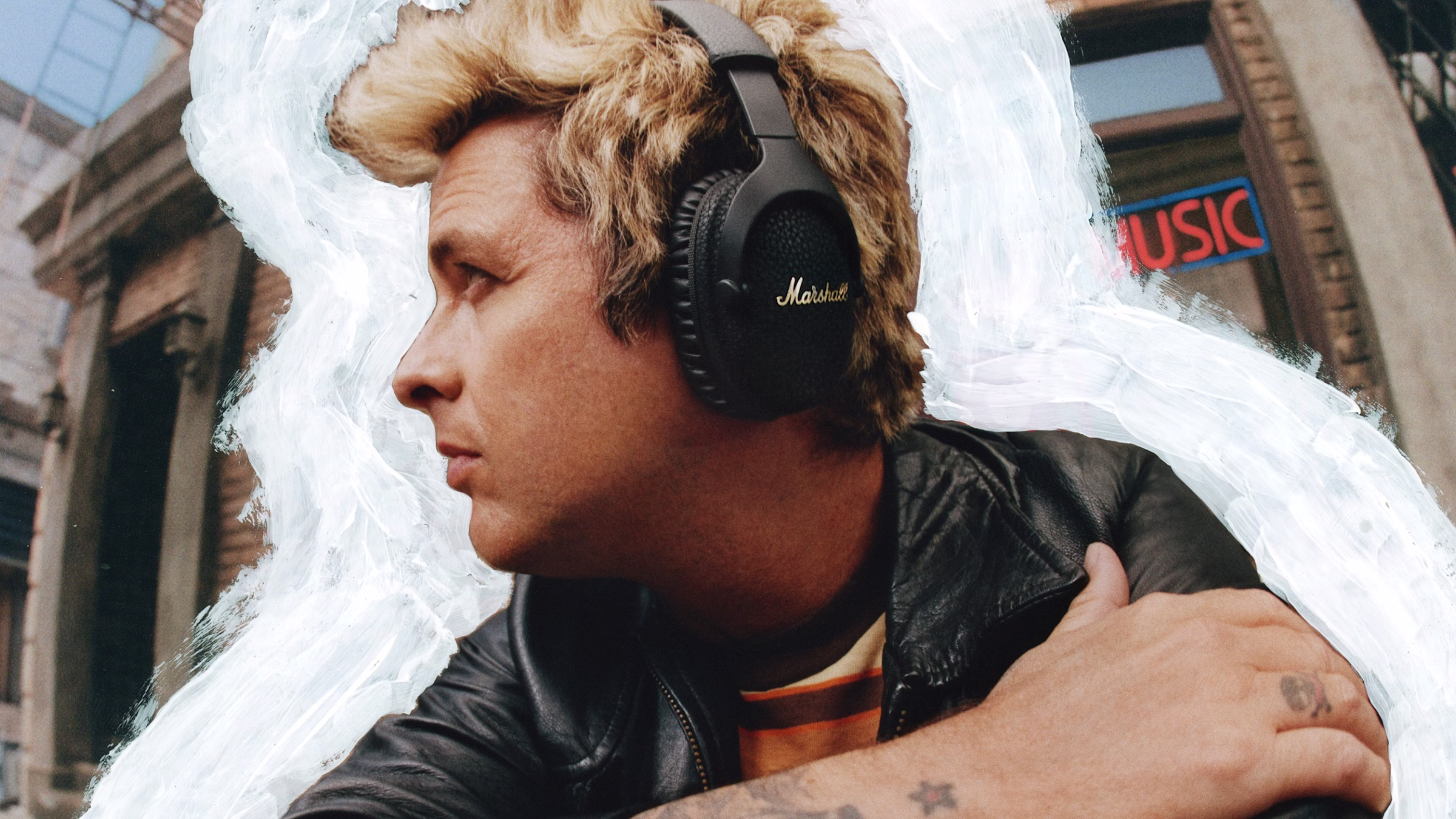 Billie Joe Armstong schaut weg und trägt einen Marshall-Over-Ear-Kopfhörer.