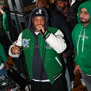 A person with a green jacket sings