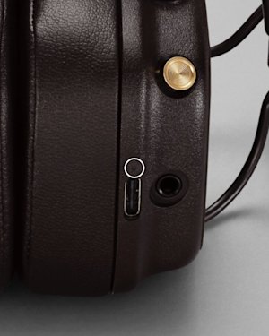 The LED indicator on a pair of brown Major IV headphones, marked with a circle.