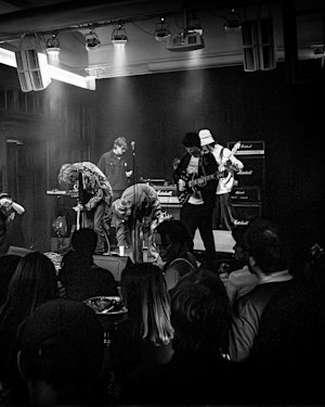 Una foto en blanco y negro de un concierto en un local pequeño.