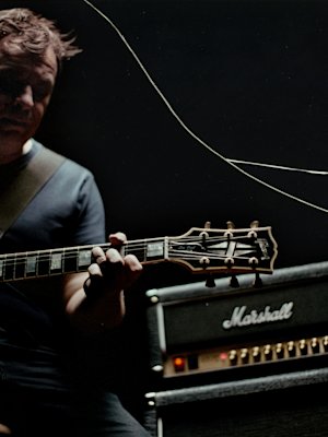 Hombre tocando la guitarra con su Studio 900 de fondo