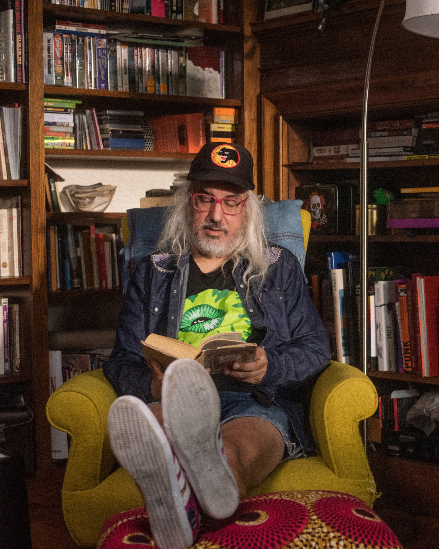 Image of J Mascis sitting in an armchair and reading