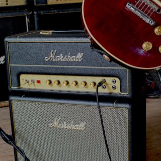 Marshall Studio Vintage Heads and combo guitars on a wooden floor.