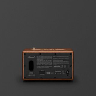 A rear view of a brown Marshall Acton III Bluetooth home speaker, showing its ports, control panel, and product information label against a dark background.