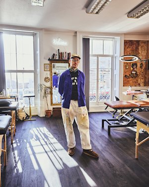 Una persona de pie en medio de una sala de tatuajes del Welcome Studio