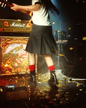 A person playing guitar on stage in front of Marshall JCM900 Woodsnake 2025 Edition Half Stack.