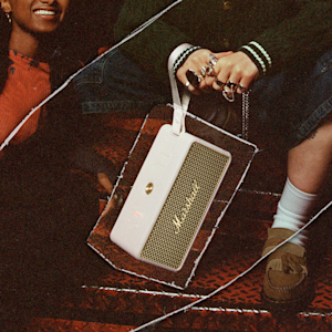 The Marshall Middleton II Cream speaker held by the strap