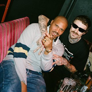 2 musicians posing together for a photo.