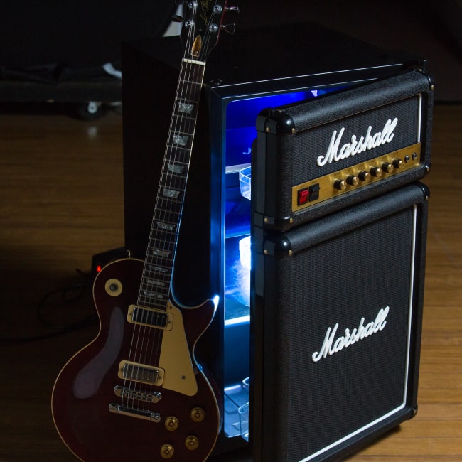 The opened Marshall fridge with a guitar on its side.