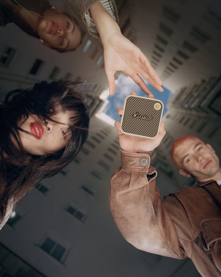 Un groupe de personnes brandissant un haut-parleur sans fil Marshall WILLEN CREAM.