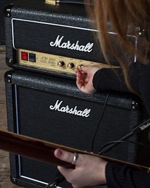 Una persona afinando el sonido medio del cabezal Marshall JCM800 2203 Vintage Reissue