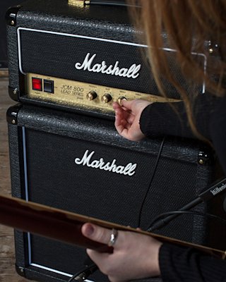 Una persona afinando el sonido medio del cabezal Marshall JCM800 2203 Vintage Reissue