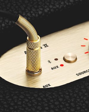 An AUX cable inserted into the AUX port on top of an Acton II Bluetooth speaker.