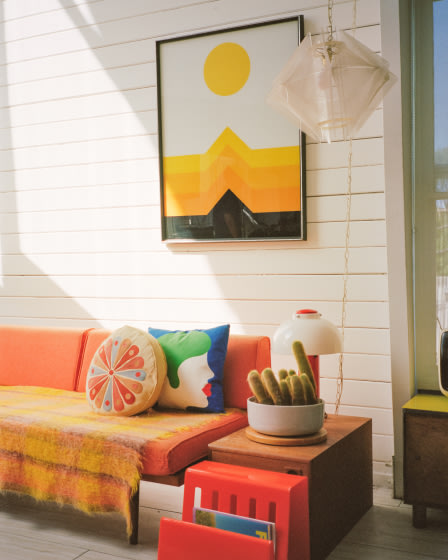 An orange couch in a living room.