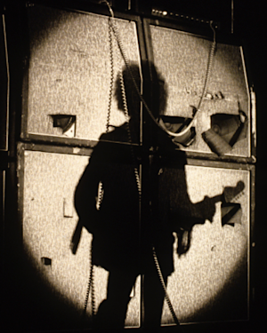 The shadow of a Guitarist in front of the Marshall amps.