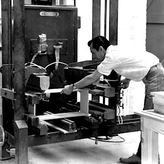 A Marshall factory worker cutting the frame for a Marshall amplifier