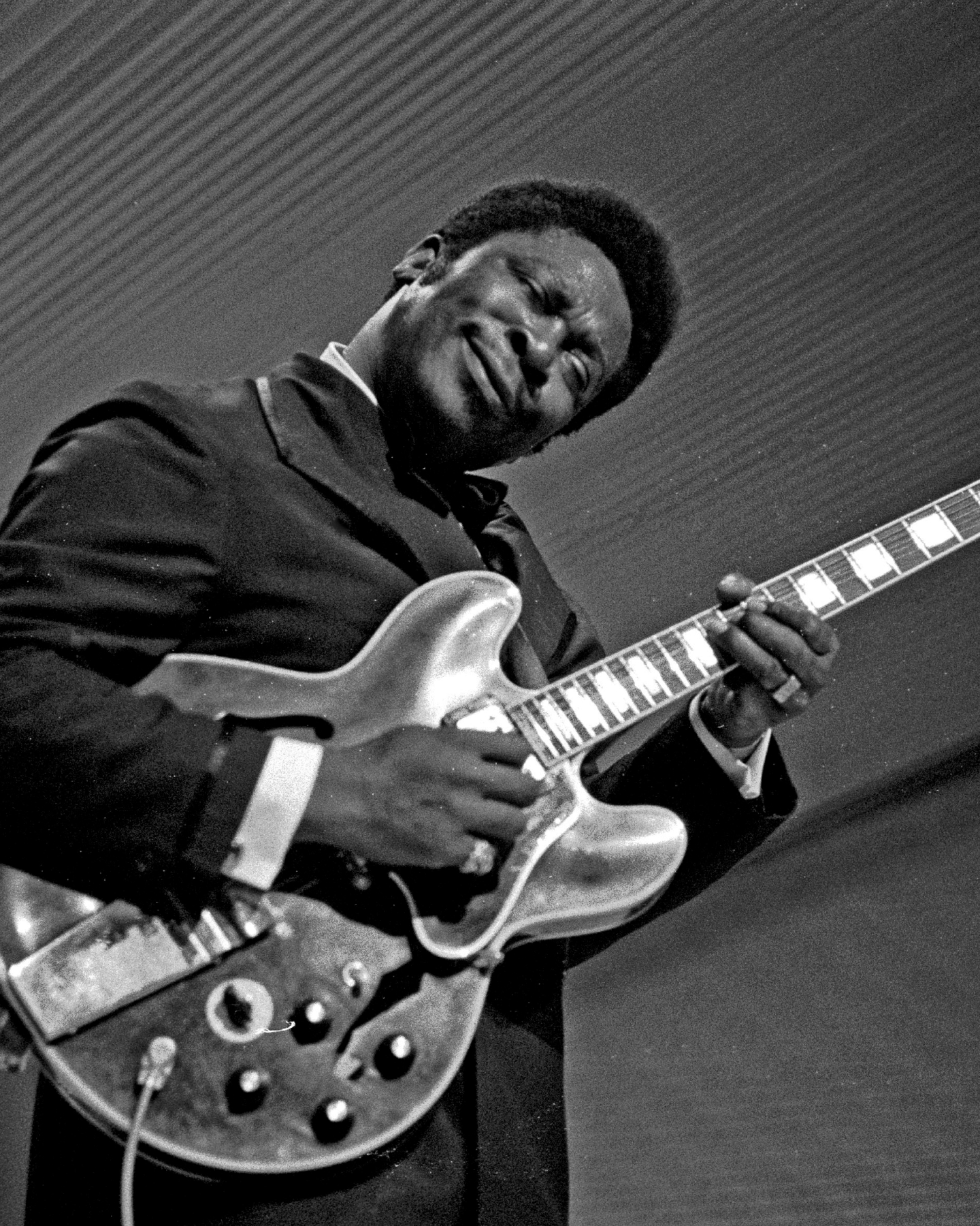 Black and white image of B.B. King playing his guitar Lucille on stage