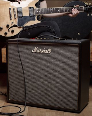 Un guitarrista tocando la guitarra conectado a un amplificador Marshall en su salón