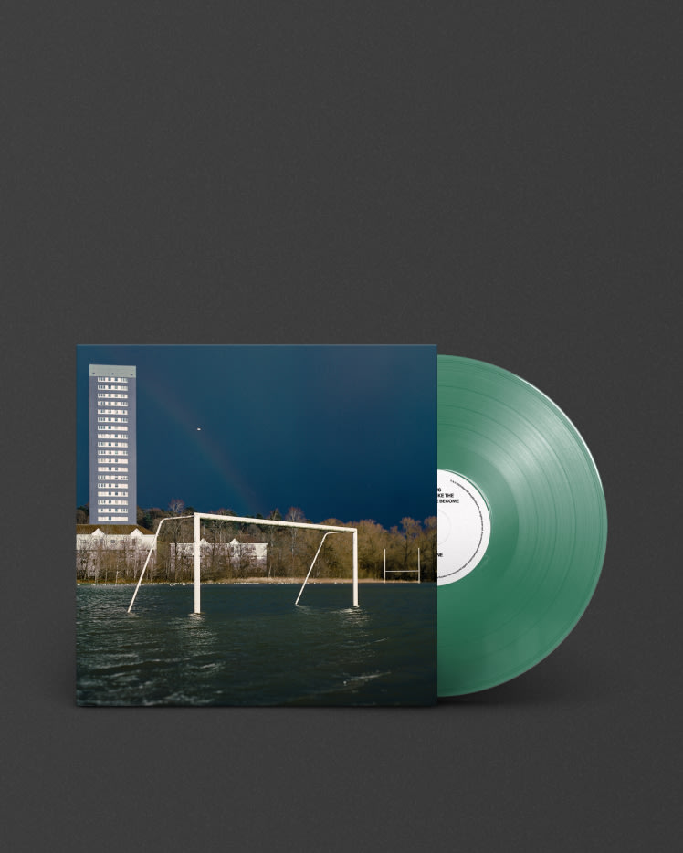 A green vinyl LP of "We Don't Like The People We've Become" by Gallus with a building in the background.