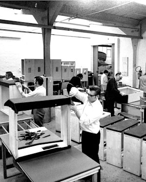 A black and white photo of people working in a factory, captured by Marshall JVM205 Combo.