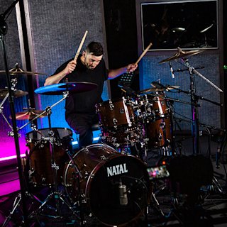 Noah See playing in a brown Natal drum kit