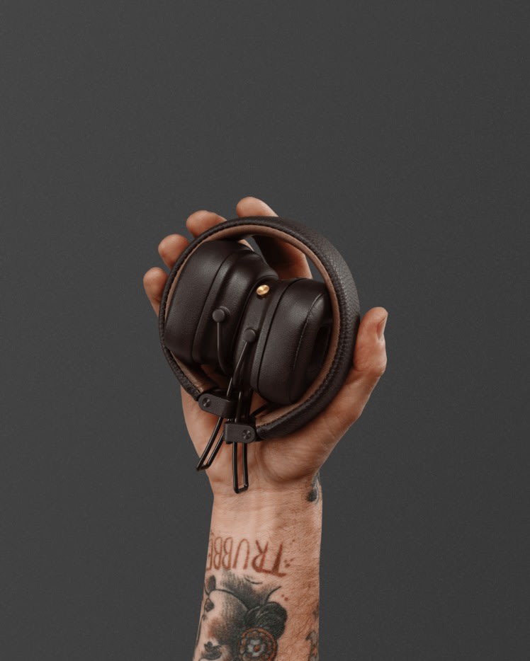 Mano sosteniendo unos auriculares Marshall Major IV Brown over-ear