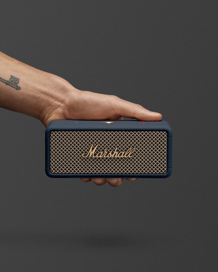 Marshall Emberton III Midnight Blue portable speaker with its gold mesh front and logo, set against a plain dark background.