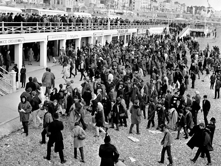 A black and white image of people on the beach