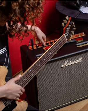 A man tuning the 'Marshall Origin20 Combo' amplifier.